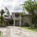 Image of the outside of this El Valle fixer upper with trees and green spaces