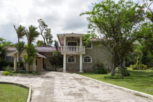 Image of the outside of this El Valle fixer upper with trees and green spaces