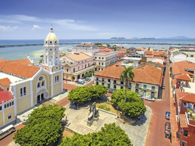 Aerial view of historic town square with church and coastal scenery