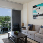 Image of living room with balcony, table and couch in this condo for sale in Olas del Mar